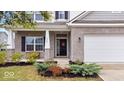 Inviting front porch with brick accents and well-maintained landscaping at 6507 W Whispering Way, Greenfield, IN 46140