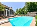 Beautiful backyard with a refreshing in-ground pool, screened porch, shed, and lounge area perfect for relaxing and entertaining at 6580 Kings Ct, Avon, IN 46123