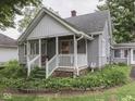 View of the front of a quaint cottage-style home with a cozy porch and lush garden at 70 Fairground St, Franklin, IN 46131