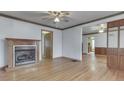 Spacious living room with hardwood floors, a fireplace, ceiling fan, and wood-trimmed walls at 70 Fairground St, Franklin, IN 46131