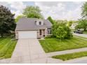 Attractive single-Gathering home with a brick facade, a wide driveway, and mature landscaping at 7402 Northfield Blvd, Fishers, IN 46038