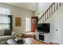 Inviting living room with a cozy fireplace, a staircase, and a view to the entry at 7402 Northfield Blvd, Fishers, IN 46038