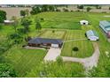 Expansive aerial view of a property featuring a brick house, large green yard, and outbuildings at 7447 S 25 E, Pendleton, IN 46064