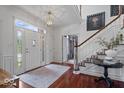 Bright foyer with hardwood floors, staircase, and elegant lighting at 9973 Woods Edge Dr, Fishers, IN 46037