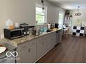 Kitchen featuring granite counters, grey cabinets, stainless appliances, hardwood floors, and an eat-in area at 101 E Hill Valley E Dr, Indianapolis, IN 46227