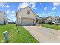 A view of the front of the home with a two car garage and long driveway at 10693 Newgate Ln, Indianapolis, IN 46231
