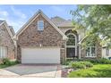Charming brick home boasts a two-car garage, arched entryway, and meticulously maintained landscaping at 11244 Blackwalnut Pt, Indianapolis, IN 46236