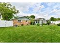 Spacious backyard with green lawn and a partial view of the house at 121 Mulberry Dr, Chesterfield, IN 46017