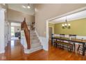 Inviting foyer with hardwood floors, staircase, and adjacent dining room at 12772 Tram Ln, Carmel, IN 46032