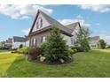Landscaped side yard showcasing lush greenery and a well-maintained lawn surrounding this house at 1521 Avondale Dr, Westfield, IN 46074
