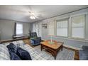Comfortable living room with a plaid sofa, ceiling fan, and a cozy sitting area bathed in soft, natural light at 1641 Winton Ave, Speedway, IN 46224
