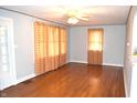 Bright living room with polished hardwood floors, vintage ceiling fan, and natural light streaming through patterned curtains at 1641 Winton Ave, Speedway, IN 46224