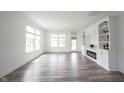 Inviting living room featuring hardwood floors, large windows, and a cozy fireplace at 19800 Sutton Ter, Westfield, IN 46074