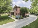 Brick home with lush landscaping, a balcony, and a driveway leading to a side-entry garage at 20 Forrests Edge Ct, Indianapolis, IN 46227