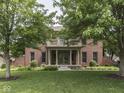 Beautiful brick home featuring a well-maintained lawn, mature trees, and a covered front porch at 20 Forrests Edge Ct, Indianapolis, IN 46227