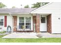 Close-up of front porch with brick accents, seating, and welcome sign, offering a cozy entrance at 254 Bittersweet Dr, Whiteland, IN 46184