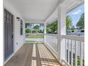 Inviting front porch with wood flooring, classic white columns, and serene neighborhood views at 300 N Church St, Arcadia, IN 46030