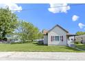 Quaint single-story home with a large lawn, tree, and traditional siding at 310 W Jackson St, Alexandria, IN 46001