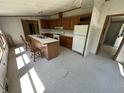 Kitchen area with wood cabinets, kitchen island, white refrigerator, and linoleum tile floors at 3587 Lower Patton Park Rd, Martinsville, IN 46151