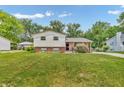 Two-story home featuring brick and siding exterior, a green lawn, and mature trees in a residential neighborhood at 3624 Woodcliff Dr, Indianapolis, IN 46203