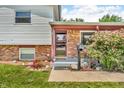 Inviting front porch with brick accents, blossoming shrubbery, and a pathway leading to the front door at 3624 Woodcliff Dr, Indianapolis, IN 46203