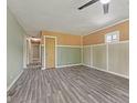 Spacious living room featuring modern gray wood flooring, and neutral paint colors with classic wainscoting at 3898 S Randolph St, Indianapolis, IN 46227
