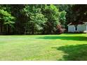 Expansive green backyard with mature trees and a glimpse of the home's architecture at 5654 Paradise Dr, Martinsville, IN 46151
