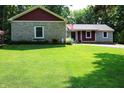 Charming home featuring stone accents, red siding, and a well-manicured front lawn at 5654 Paradise Dr, Martinsville, IN 46151