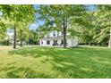 Charming two-story home with a sprawling green lawn surrounded by mature trees, offering a serene setting at 5710 W 650 N, Thorntown, IN 46071