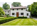 Charming two-story home featuring a brick-accented entryway and beautifully landscaped front yard with manicured hedges at 5805 Forest Ln, Indianapolis, IN 46220