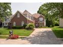 Lovely two-story brick home with beautiful landscaping, a two-car garage, and a large driveway at 6483 Royal Oakland Dr, Indianapolis, IN 46236