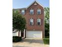 Inviting brick townhome showcasing dark shutters, a pristine white garage door, and lush green landscaping at 6927 Havenmoor Pl, Indianapolis, IN 46250