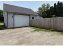 Detached two-car garage with gravel driveway and fenced perimeter for added privacy at 707 S Harrison St, Alexandria, IN 46001