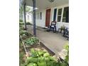 Charming front porch with red front door, blue shutters, and rocking chairs at 828 N Clarkdale Dr, Muncie, IN 47304