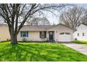 Well maintained single-story home with front lawn, driveway and mature trees in residential neighborhood at 829 Meadow Ln, Greenfield, IN 46140