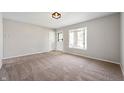 Bright living room featuring a new carpet, neutral walls, and a large front window at 829 Meadow Ln, Greenfield, IN 46140