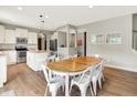 Bright dining room with white chairs, wood table, hardwood floors, and an open layout to the kitchen at 848 Silverheels Dr, Westfield, IN 46074