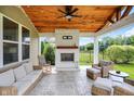 Cozy outdoor patio featuring a fireplace, comfortable seating, ceiling fan, and wooden ceiling at 848 Silverheels Dr, Westfield, IN 46074