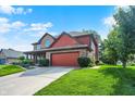 Spacious two-story home with brick and red siding, a two-car garage, and a well-maintained lawn at 8619 Wrangler Ct, Indianapolis, IN 46217