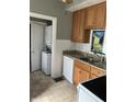 Efficient kitchen with granite countertops, tile backsplash, and adjacent laundry area at 88 N 15Th Ave, Beech Grove, IN 46107