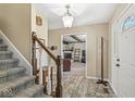 Open foyer with staircase, coat rack, and view into the living room at 9221 Holyoke Ct, Indianapolis, IN 46268