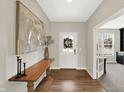 Inviting foyer with wood flooring, elegant console table, modern art, and view to a naturally lit office at 9716 Cimmaron Ave, McCordsville, IN 46055