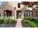 Inviting front entrance features a covered porch, a wreath-adorned front door, and carefully manicured landscaping at 10054 Win Star Way, Fishers, IN 46040