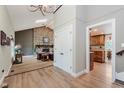 Open-concept living room with stone fireplace, skylight, and hardwood floors at 102 Roxbury Ln, Noblesville, IN 46062
