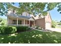 Beautiful home with a inviting front porch, manicured lawn, and attached two-car garage at 10760 Independence Way, Carmel, IN 46032