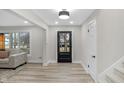 Bright entryway with stylish light fixture, black front door, and staircase leading to the second floor at 11035 W Lakeshore Dr, Carmel, IN 46033