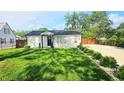 Charming single story house with verdant front yard and decorative landscape at 1125 S Drexel Ave, Indianapolis, IN 46203