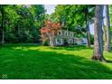 Two-story home surrounded by mature trees, featuring an attached garage and well-manicured lawn at 11510 Ralston Ave, Carmel, IN 46032