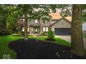 Charming two-story home with a brick and vinyl exterior, black mulch beds, and well-manicured lawn at 11987 Quarry Ct, Fishers, IN 46037