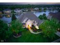 Elegant home with manicured lawn, gardens, and water views in a scenic community at 12192 Woods Bay Pl, Carmel, IN 46033